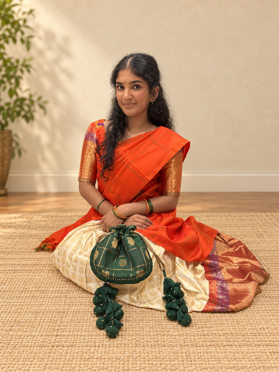 Label Madras green potli styled with an orange and cream saree